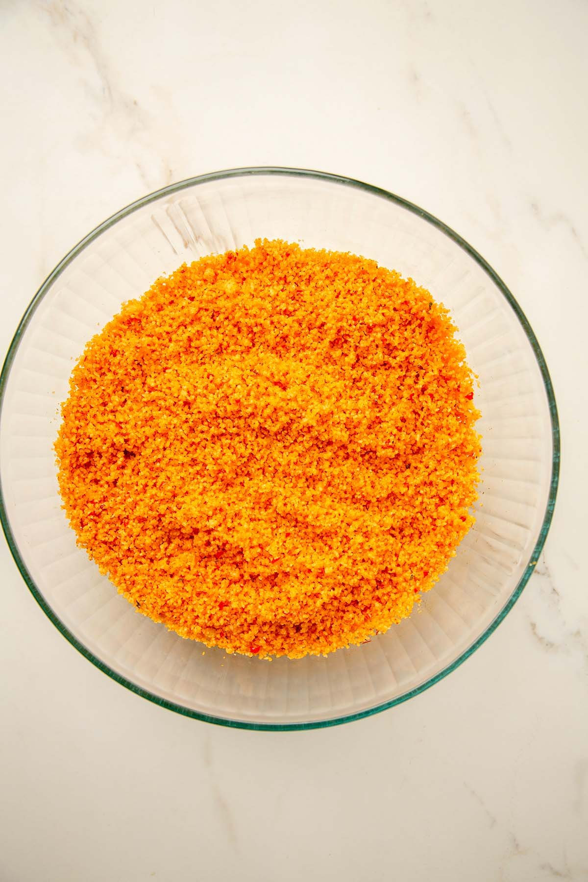 Hydrated bulgur evenly mixed with red pepper paste, forming the bright orange base of Kısır.
