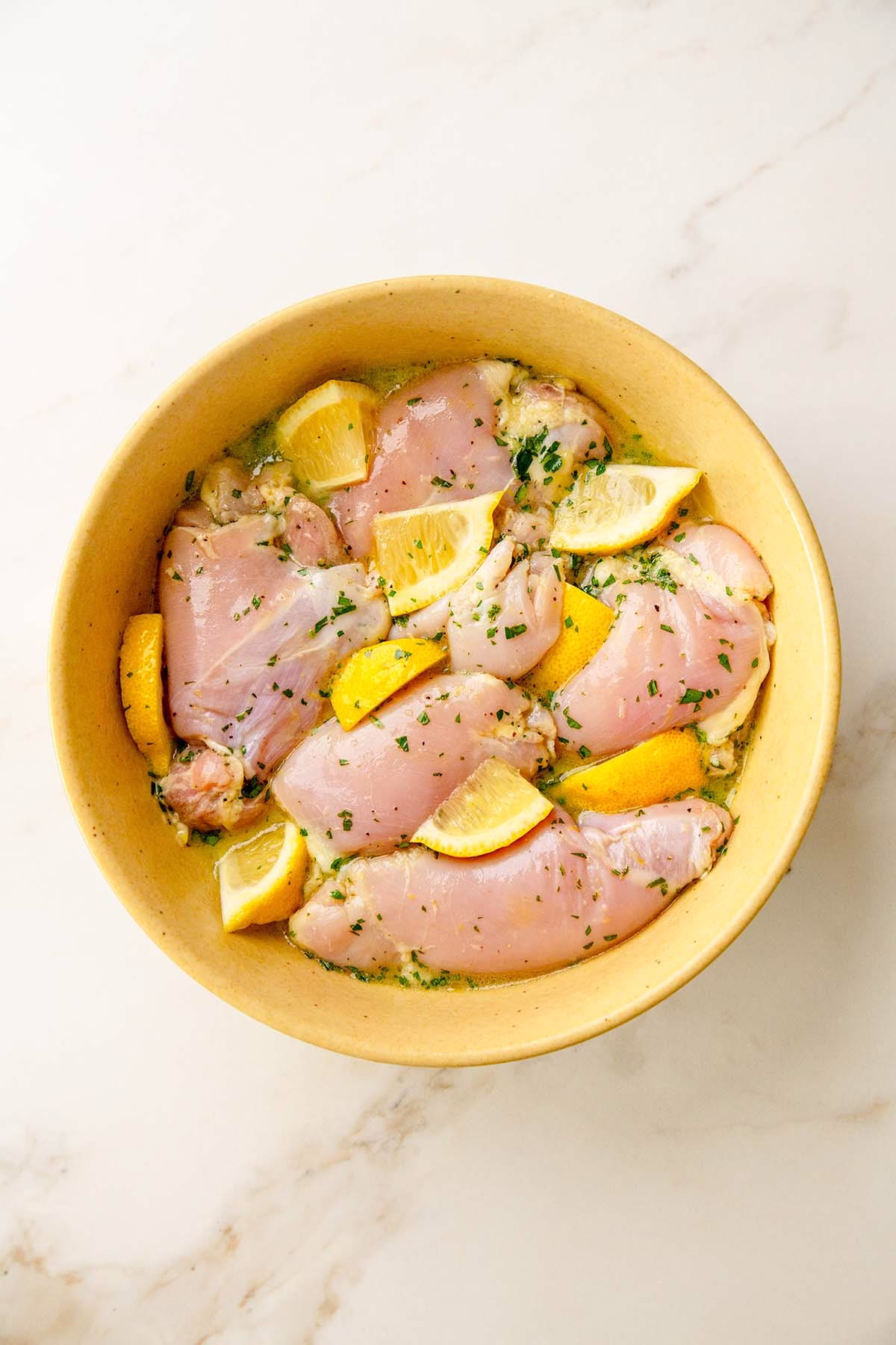 Lemon Herb Chicken Marinating with Lemons