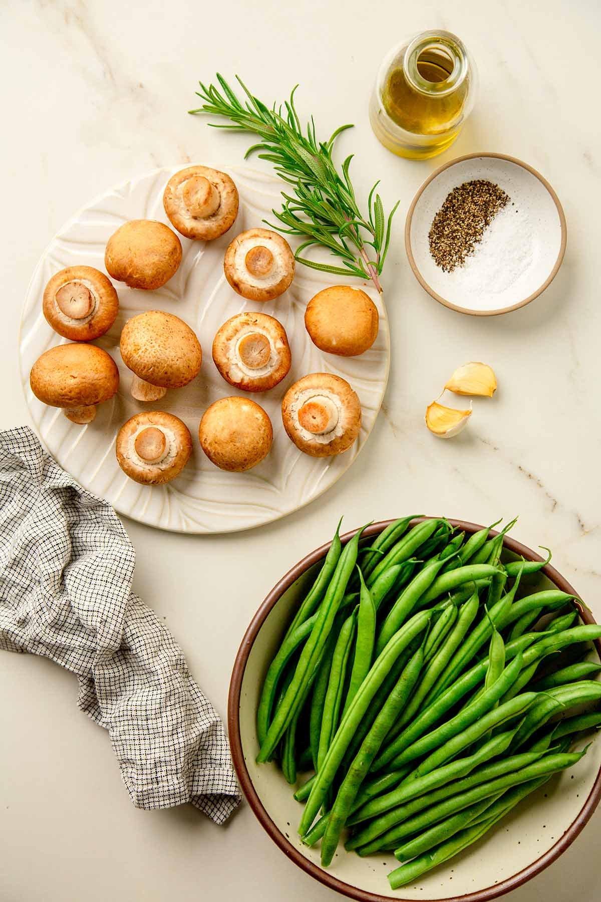 Ingredients to make roasted green beans with mush rooms; Green Beans,  mushrooms, rosemary, olive oil, and seasonings