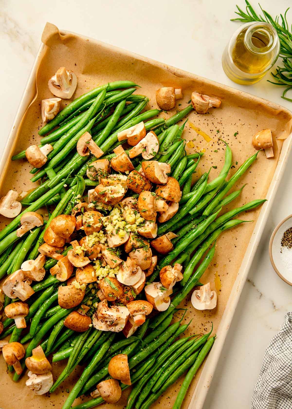 Green beans with mushrooms arranged on a sheet pan