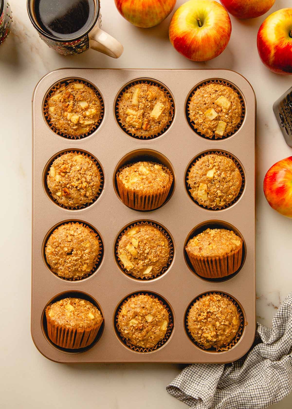 Honey apple oat muffins cooling in a pan.