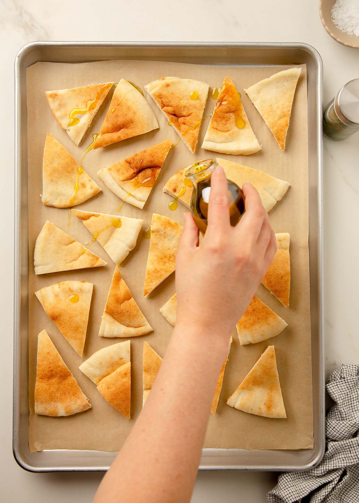 Pita bread triangles drizzled with olive oil before baking