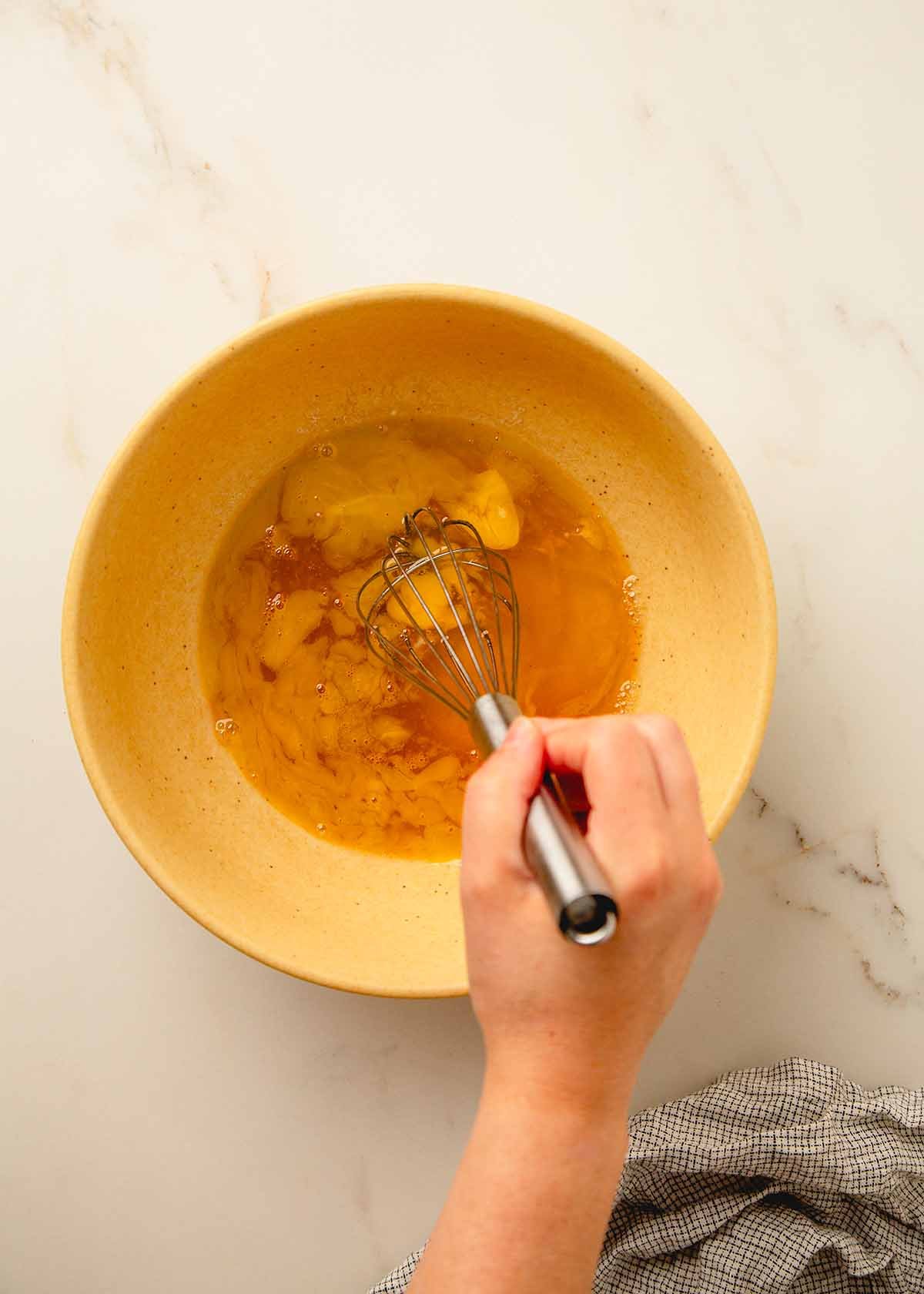 Whisking Eggs and Honey in Large Yellow Bowl