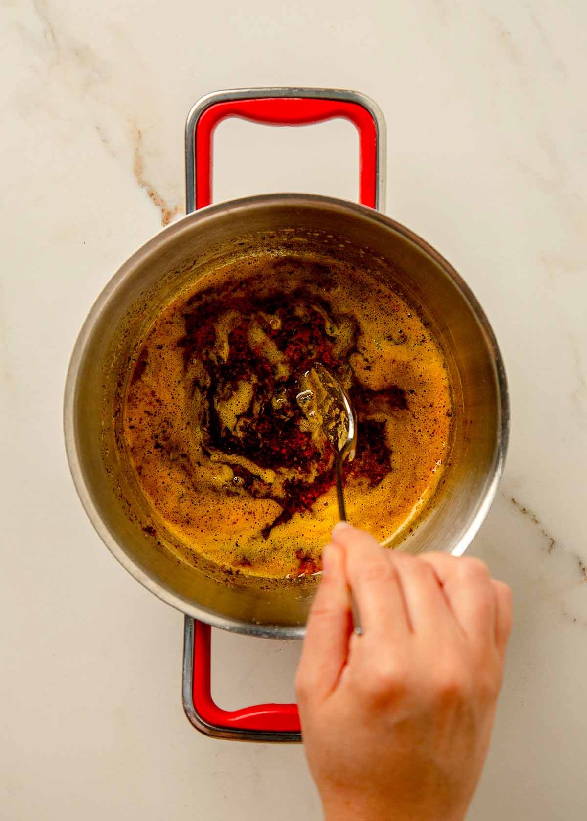 Brown butter with fresh herbs and Aleppo pepper in a small pan.