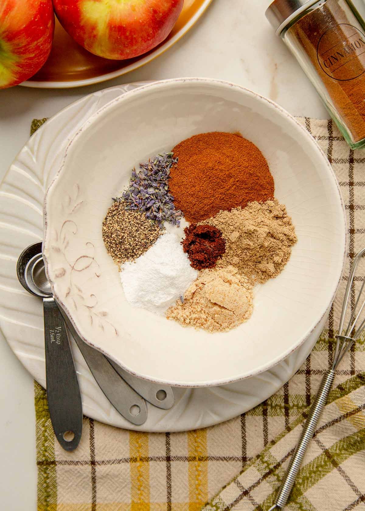 Ground cinnamon, mahlab, cardamom, and other spices in a bowl before mixing.