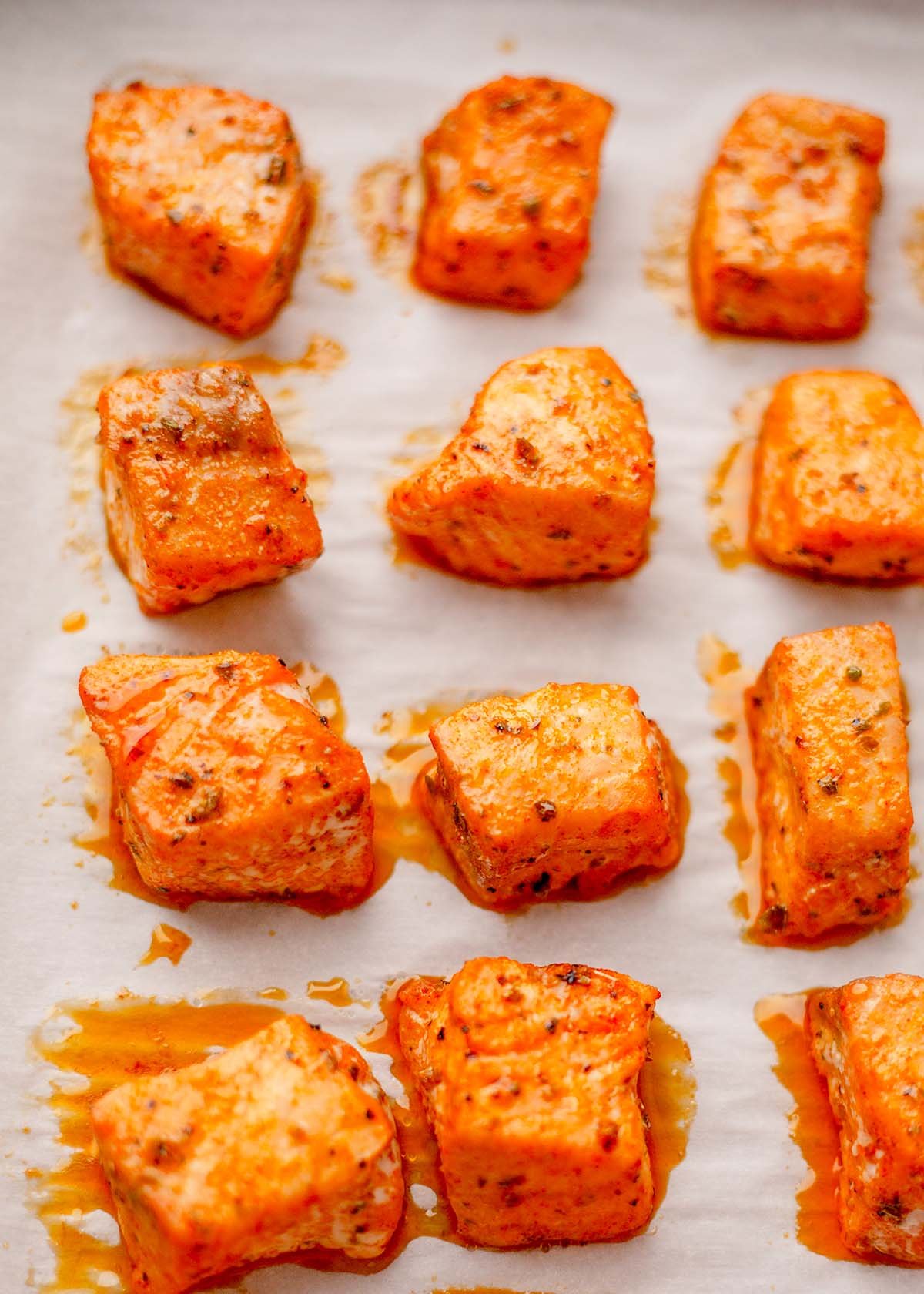 Salmon bites roasting on a sheet pan.