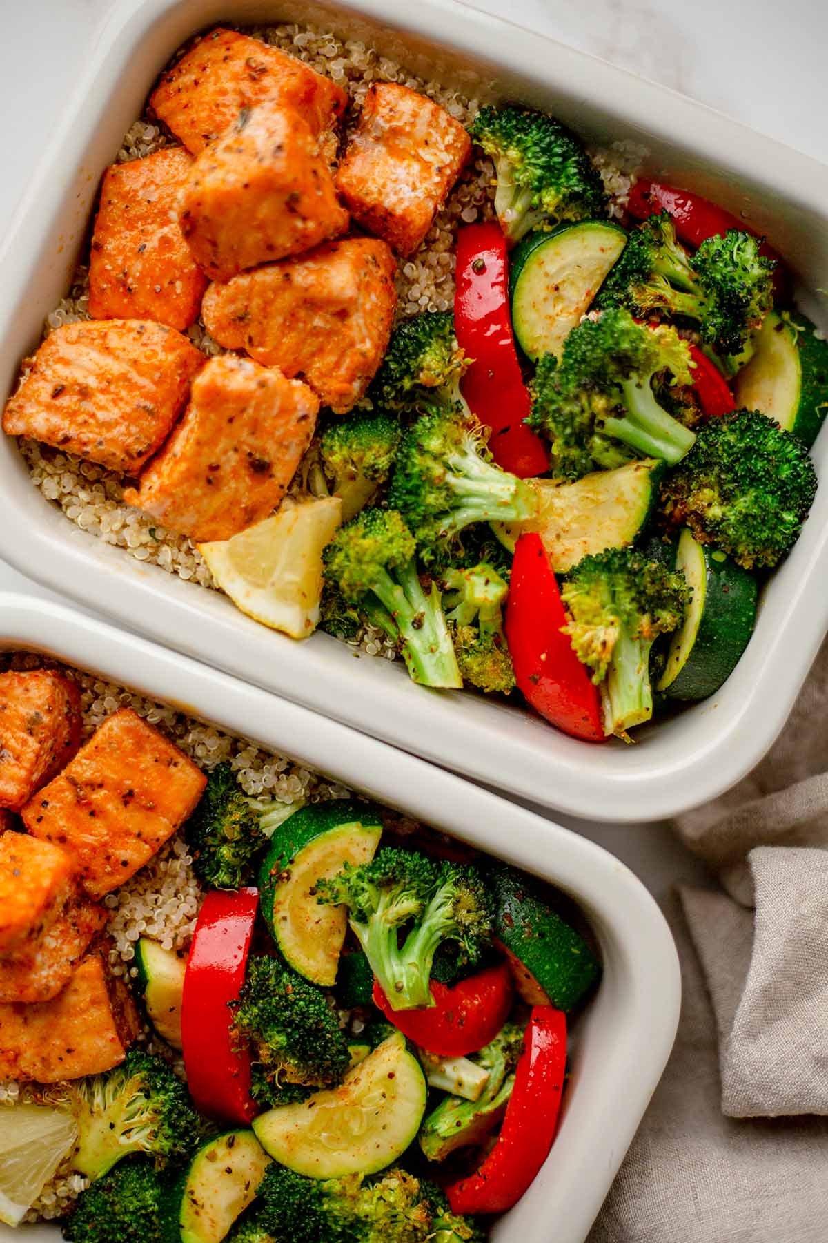 Lemon herb salmon lunch prep bowl with quinoa and roasted vegetables.