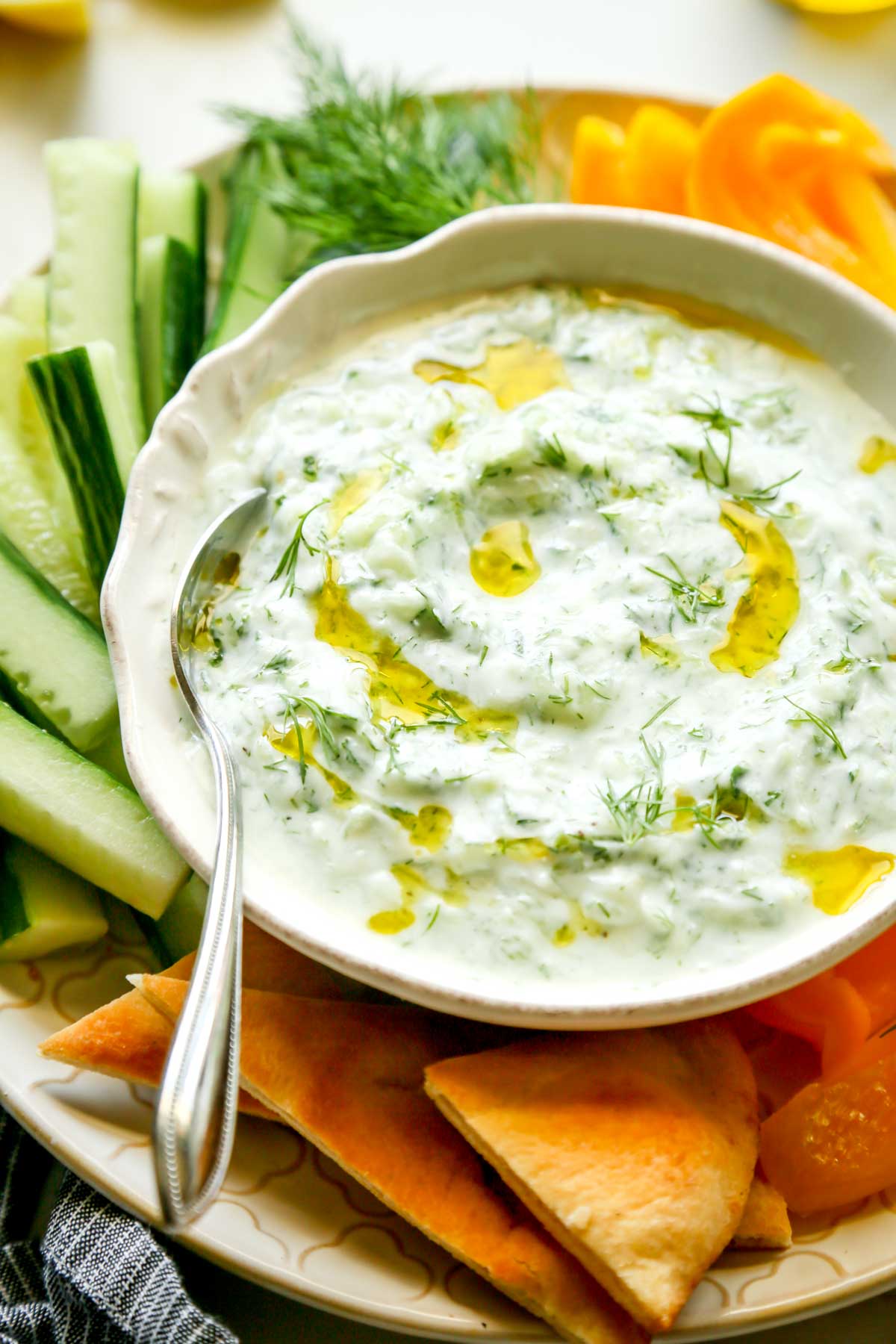 Goat Milk Tzatziki with Dill and Olive Oil Served on a Plate with Vegetables and Pita