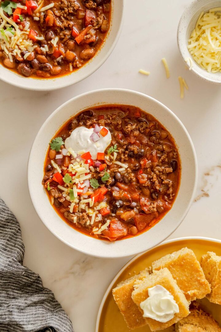 Close-up of a bowl of homemade beef chili with classic toppings