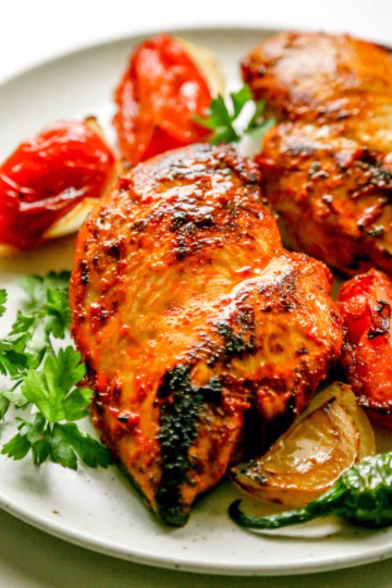 Cooked Turkish chicken served with blistered peppers, tomatoes, and onions.