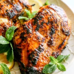 Lebanese-style chicken breasts garnished with fresh herbs and lemon slices
