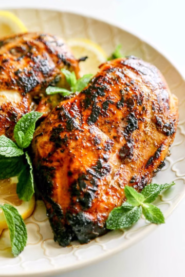 Lebanese-style chicken breasts garnished with fresh herbs and lemon slices