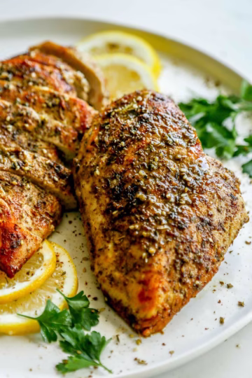 za’atar chicken breast served with lemon slices and fresh parsley