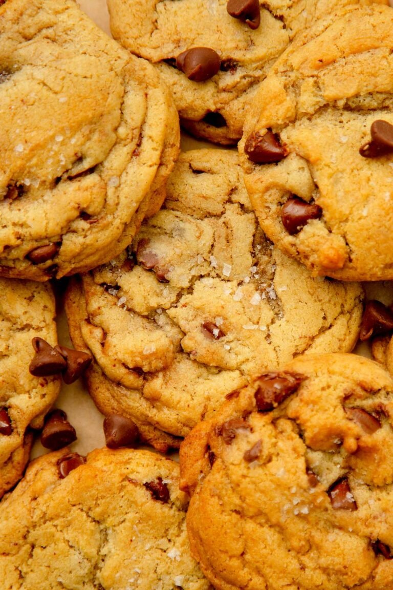 Close-up of golden-brown tahini chocolate chip cookies topped with flaky sea salt