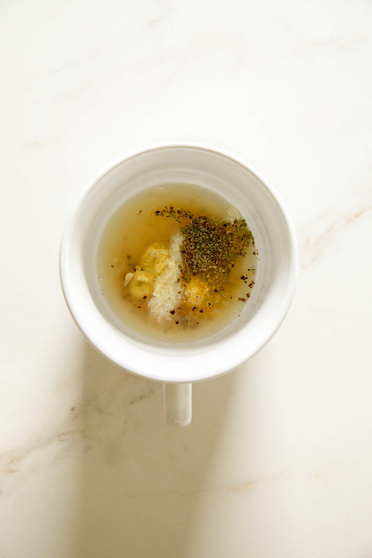 lemon juice, mustard, garlic, and oregano in a mixing bowl with salt, and pepper