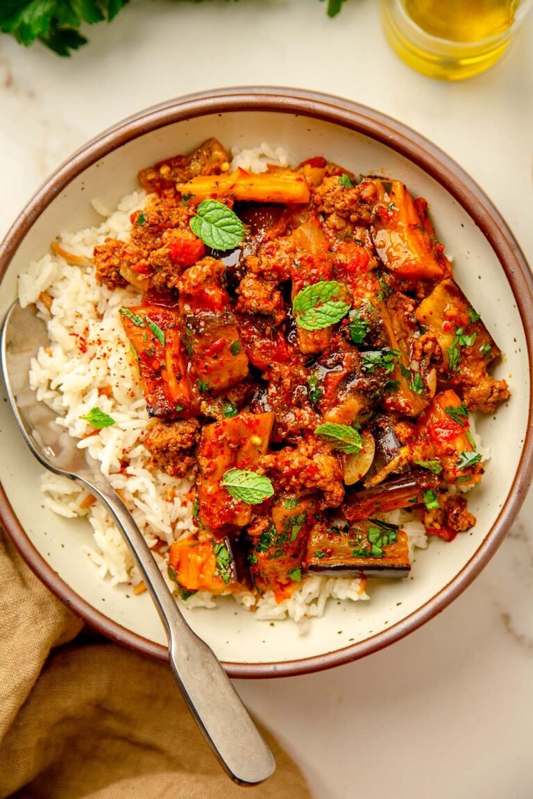 Turkish moussaka with roasted eggplant, ground beef, and rice on a white plate