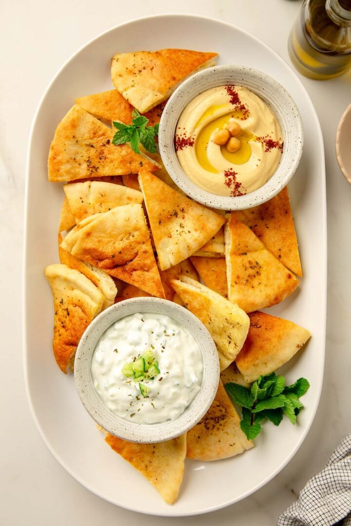 Homemade Pita Chips with Small Bowls of Tzatziki and Hummus