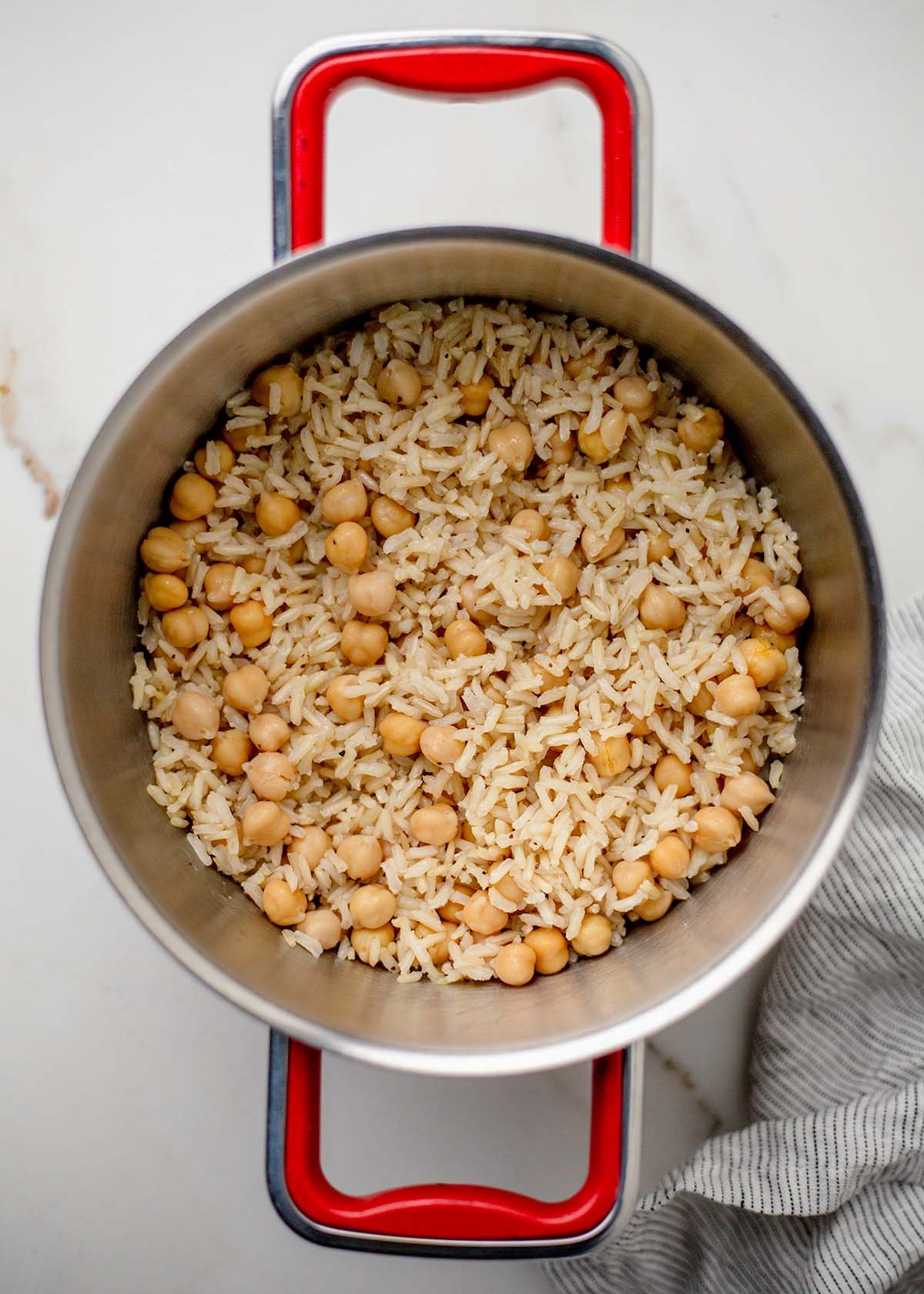 Brown rice with warmed chickpeas fluffed together in a pot.