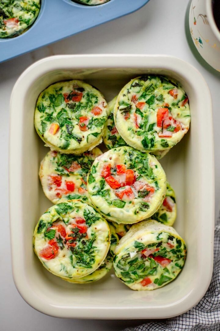 Egg white bites in meal prep container with cup of coffee