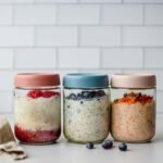 Glass jars filled with creamy overnight oats layered with fruit and toppings, showing Lemon & Blueberry, Raspberry Chia Jam, and Carrot Cake variations, ready for meal prep.