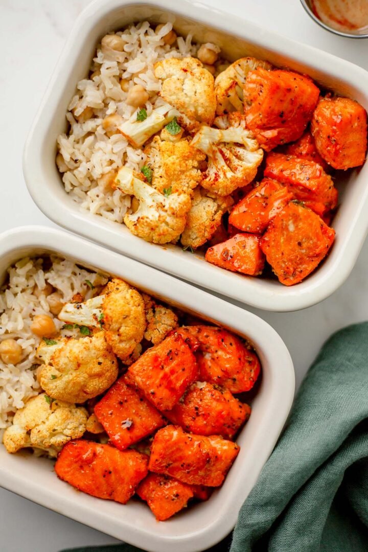 Meal prep containers of hot honey trout bites with cauliflower and rice.
