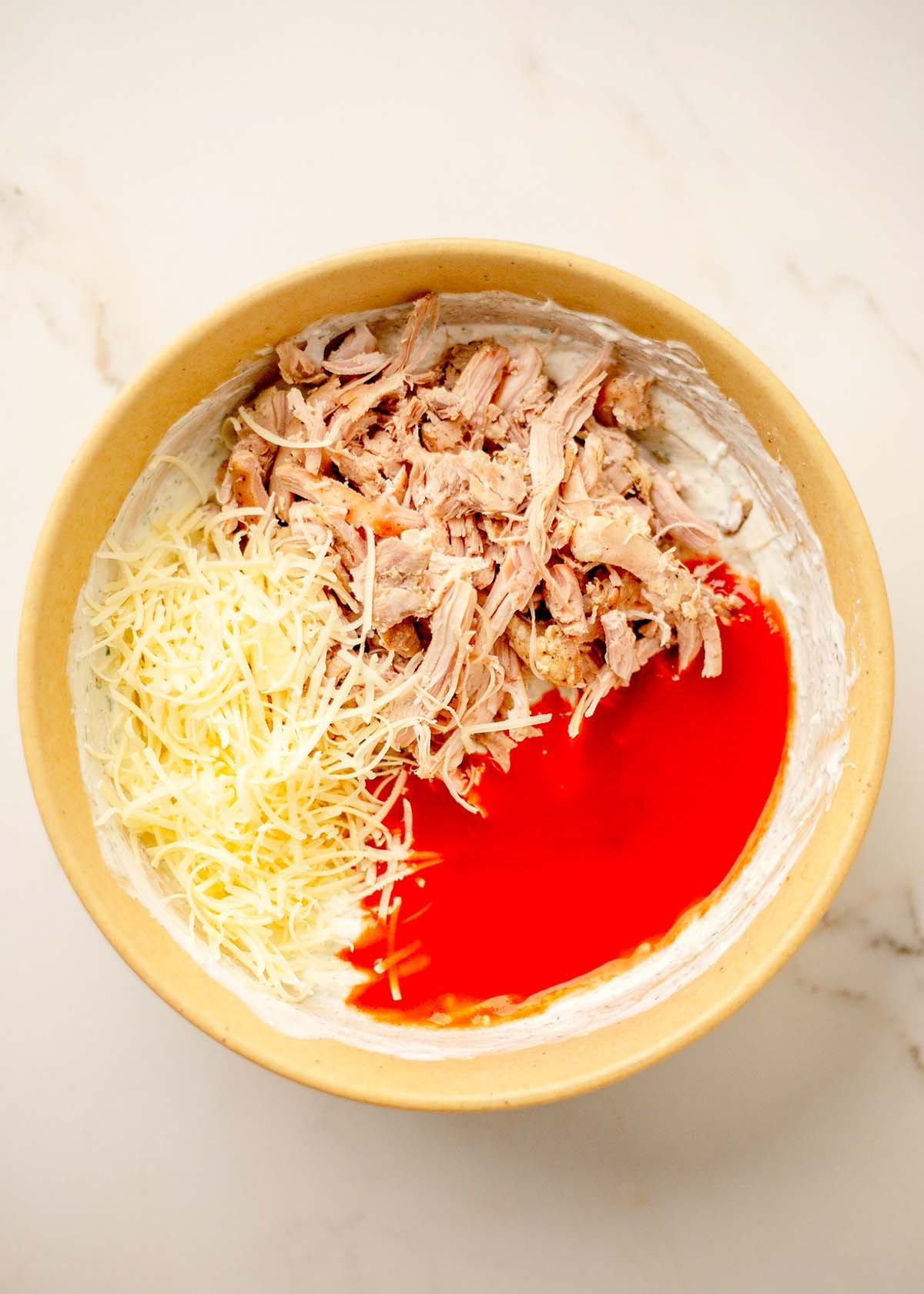 Shredded chicken and hot sauce added to the creamy base