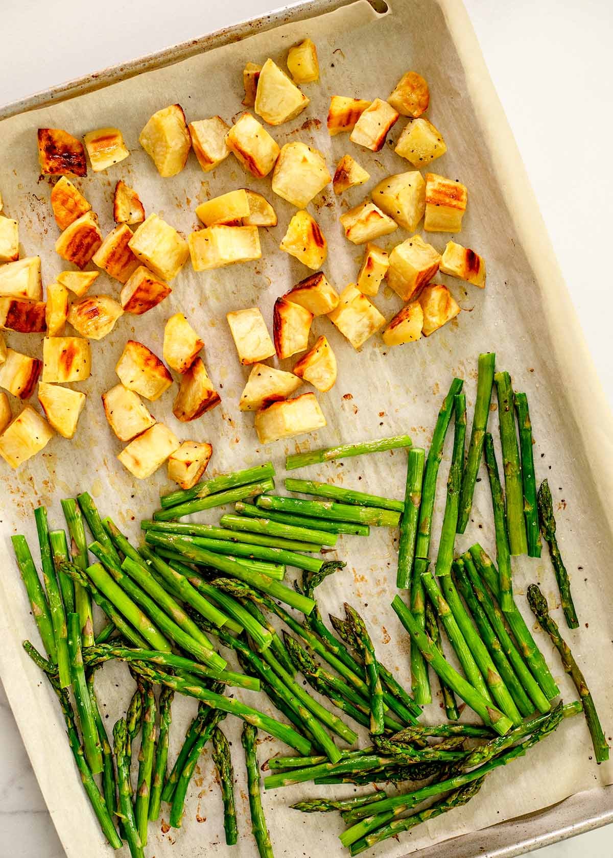 roasted asparagus and roasted sweet potatoes on a sheet pan