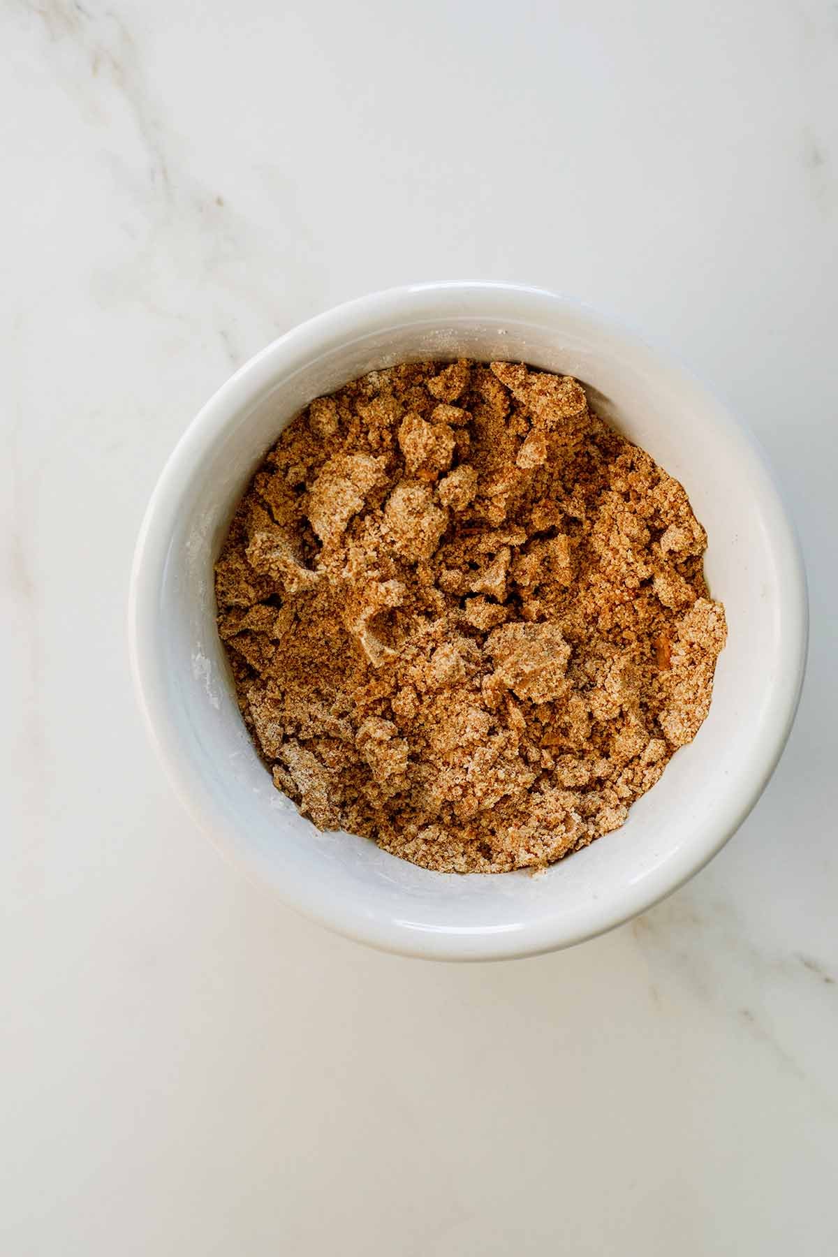 Brown sugar, cinnamon, and flour combined in a white bowl for Greek yogurt coffee cake streusel
topping.