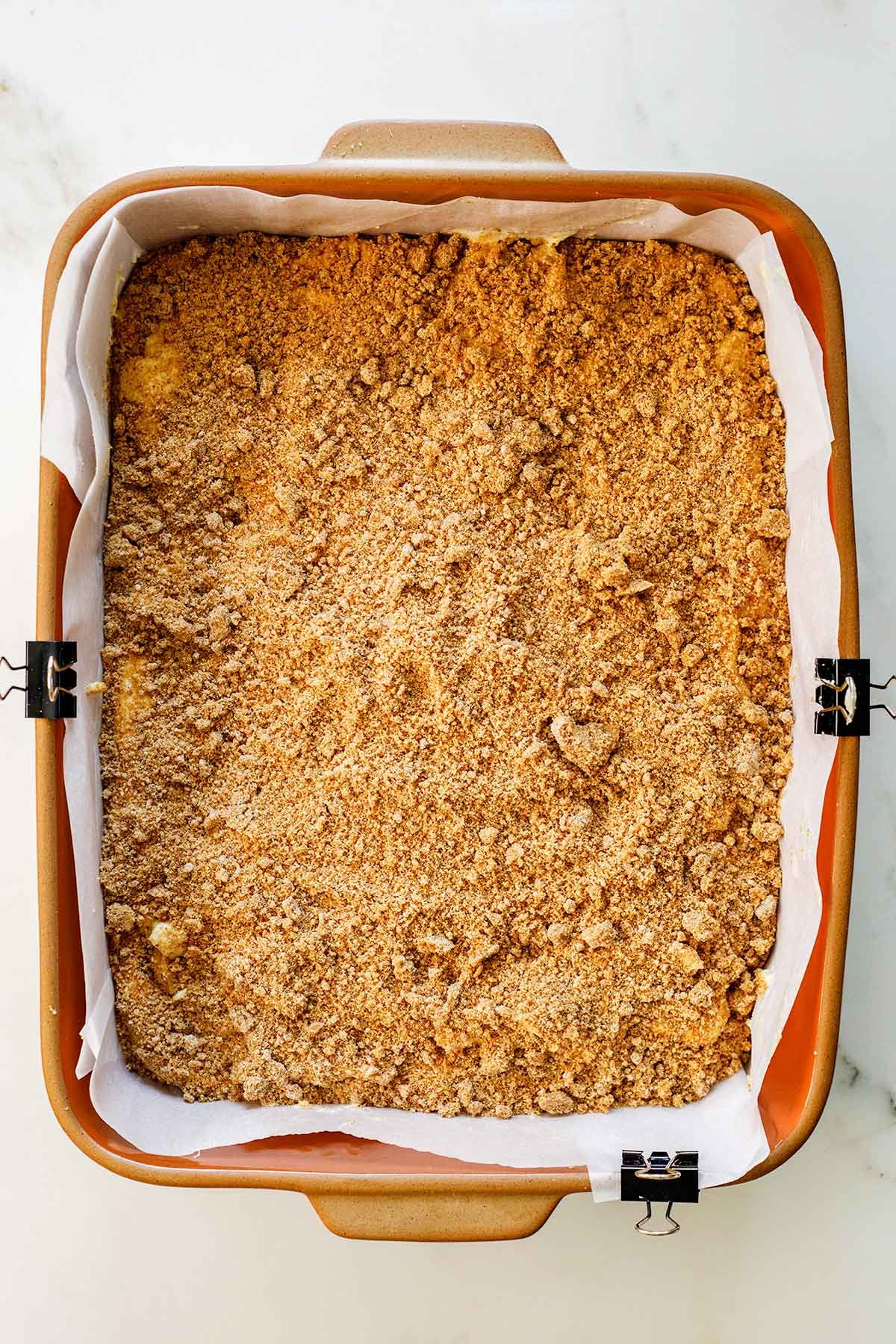 Generous cinnamon brown sugar streusel layer sprinkled evenly over Greek yogurt coffee cake
batter in a 9x13 pan, ready to bake.