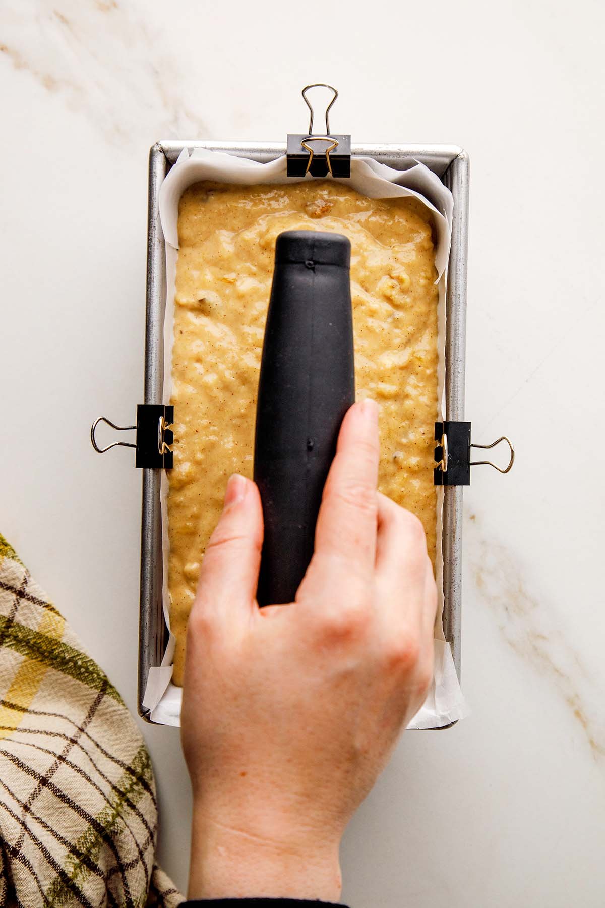 Placing Bench Scraper into Honey Banana Bread Batter Before Baking